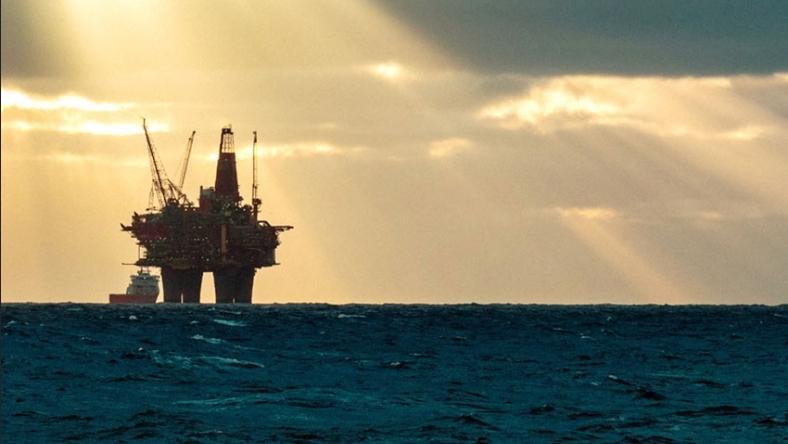 Offshore oil platform operating at sea during sunset